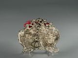 an image of a silver statue of a dog with a red bow on it ' s head