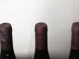 three bottles of wine sitting on a wooden table