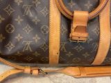 a brown and tan louis vuitton bag sitting on the floor