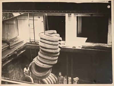 a black and white photo of a stack of tires on a boat