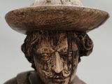 carved wooden figurine of a man with a hat on his head