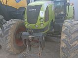 a green tractor that is parked in the dirt