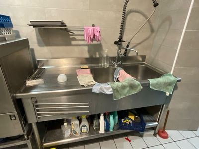 un évier de cuisine avec de nombreux produits d'entretien