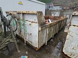 a dumpster in the middle of a dirty yard