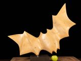 a sculpture of a bat and a green apple on a table