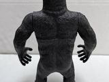 a toy gorilla that is standing on a white surface