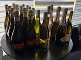 bottles of wine are lined up on a table in front of a window