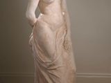 statue d'une femme debout sur un parquet, dans une pièce