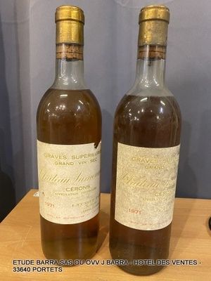 two bottles of wine sitting on top of a wooden table