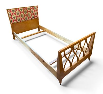 un lit avec un cadre en bois et une tête de lit à motifs floraux