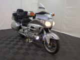 une moto argentée garée dans une pièce au sol carrelé