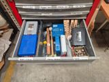 a drawer full of tools and other items in a garage