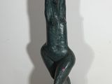 statue d'un homme assis sur une chaise, dont l'ombre se projette sur le mur