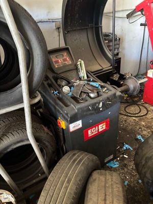 un tas de pneus et une machine à démonter les pneus dans un garage