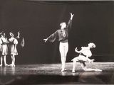 a black and white photo of a ballerina and a group of dancers