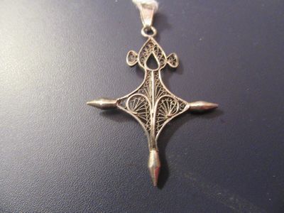 l'image d'une croix argentée posée sur une surface noire