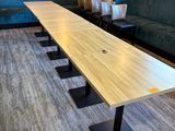 une longue table au milieu d'une pièce avec des canapés bleus