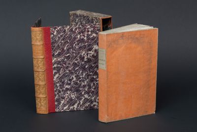 deux vieux livres posés l'un à côté de l'autre sur une surface noire