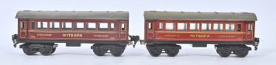 two toy trains sitting side by side on a white surface