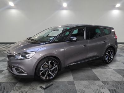 the grey car is parked on a checkered floor in a garage