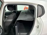 a white car with its back door open and the seats folded down