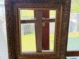 une photo d'un miroir posé sur un pied devant une fenêtre