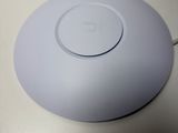 un objet rond et blanc posé sur une table, sur un fond blanc
