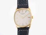a close up of a watch on a white surface with a black strap
