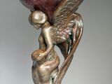 bronze sculpture of a woman holding a large ball on her head