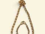an image of a gold necklace with a chain hanging from it ' s end