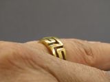 un gros plan sur la main d'une personne tenant une bague en or