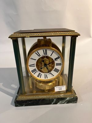 une horloge en or avec des chiffres romains, dans une vitrine