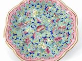 a pink and blue plate with a floral design on it