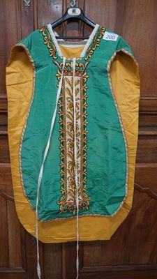 une robe verte et jaune accrochée à une porte en bois