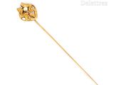 a close up of a gold stick with a flower on it