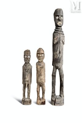 trois figurines en bois représentant un homme et une femme debout l'un à côté de l'autre
