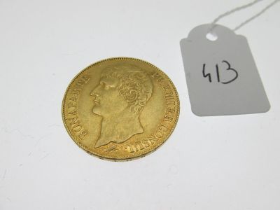 une pièce d'or « sovereign » sur laquelle est apposée une étiquette indiquant son prix