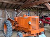 un tracteur garé dans une grange avec d'autres tracteurs