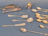 many silver spoons and forks on a blue surface