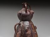 un vieux vase marron surmonté d'un oiseau