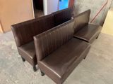 two brown leather benches sitting next to each other in a room
