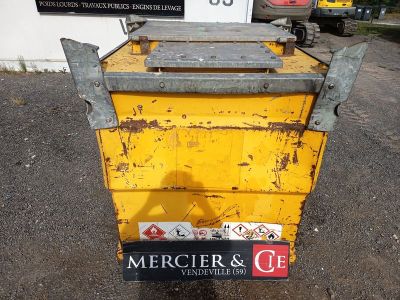 une benne jaune posée au milieu d'un parking