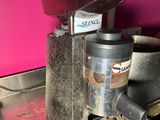 a coffee grinder sitting on top of a metal counter
