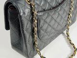 a close up of a black chanel bag with a gold chain