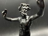 bronze statue of a man holding his hands up in the air
