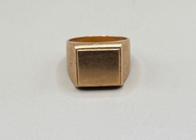 gros plan d'une bague en or sur une surface blanche