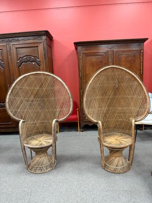 two wicker chairs in a room with a red wall