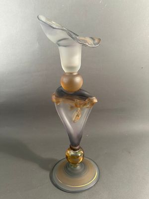 un vase en verre surmonté d'un oiseau