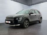 La voiture grise est garée dans une grande pièce aux murs blancs.