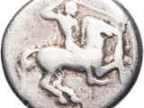 a silver coin with a horse and rider on it